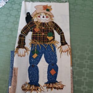 A scarecrow quilt block sitting on top of a table.