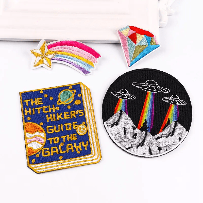 A book, rainbow kite and other patches on a table.
