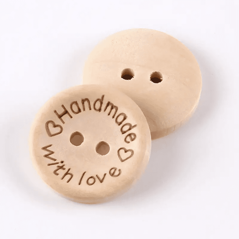 Two wooden buttons with the words handmade with love written on them.